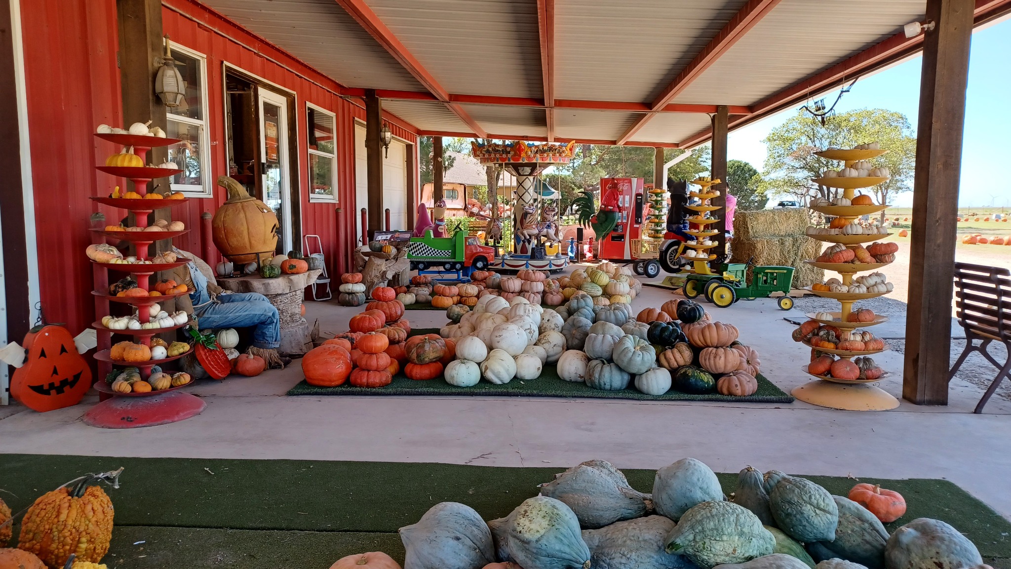 Pumpkin displays and vintage rides beneath the red porch at Assiter Punkin Ranch in Floydada, Texas